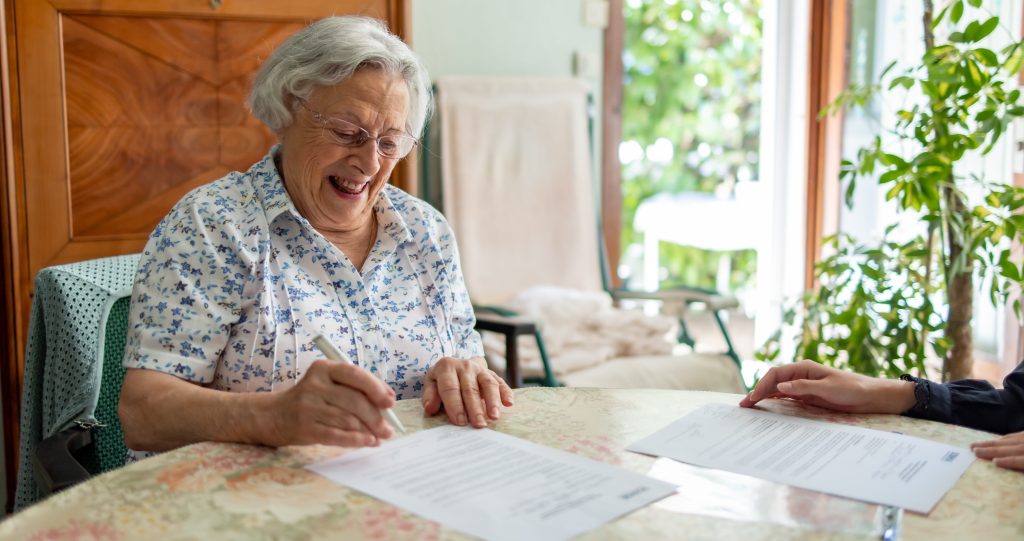 une personne âgée signe des documents